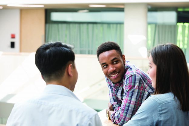 student smiling at two other students