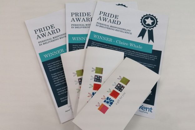 Three pride award booklets to the three Hospitality staff who each won an award